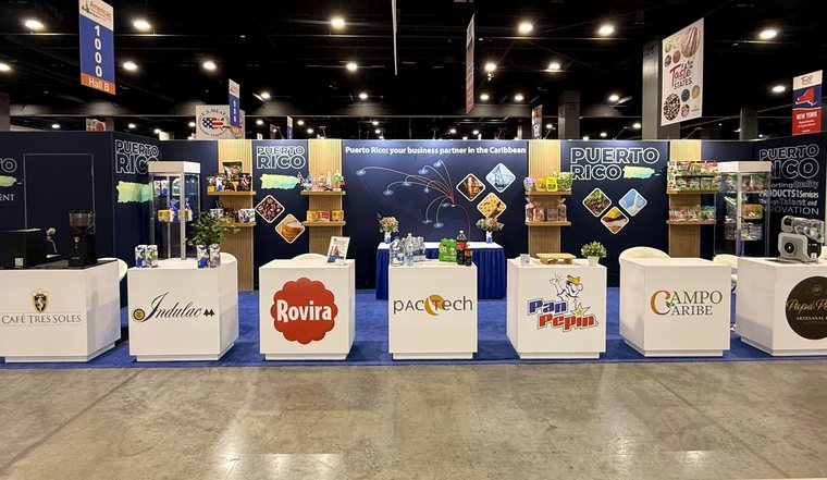 Display America–built Puerto Rico pavilion: a wood-slat exhibit with branded counters, product shelves and the PUERTO RICO wordmark.